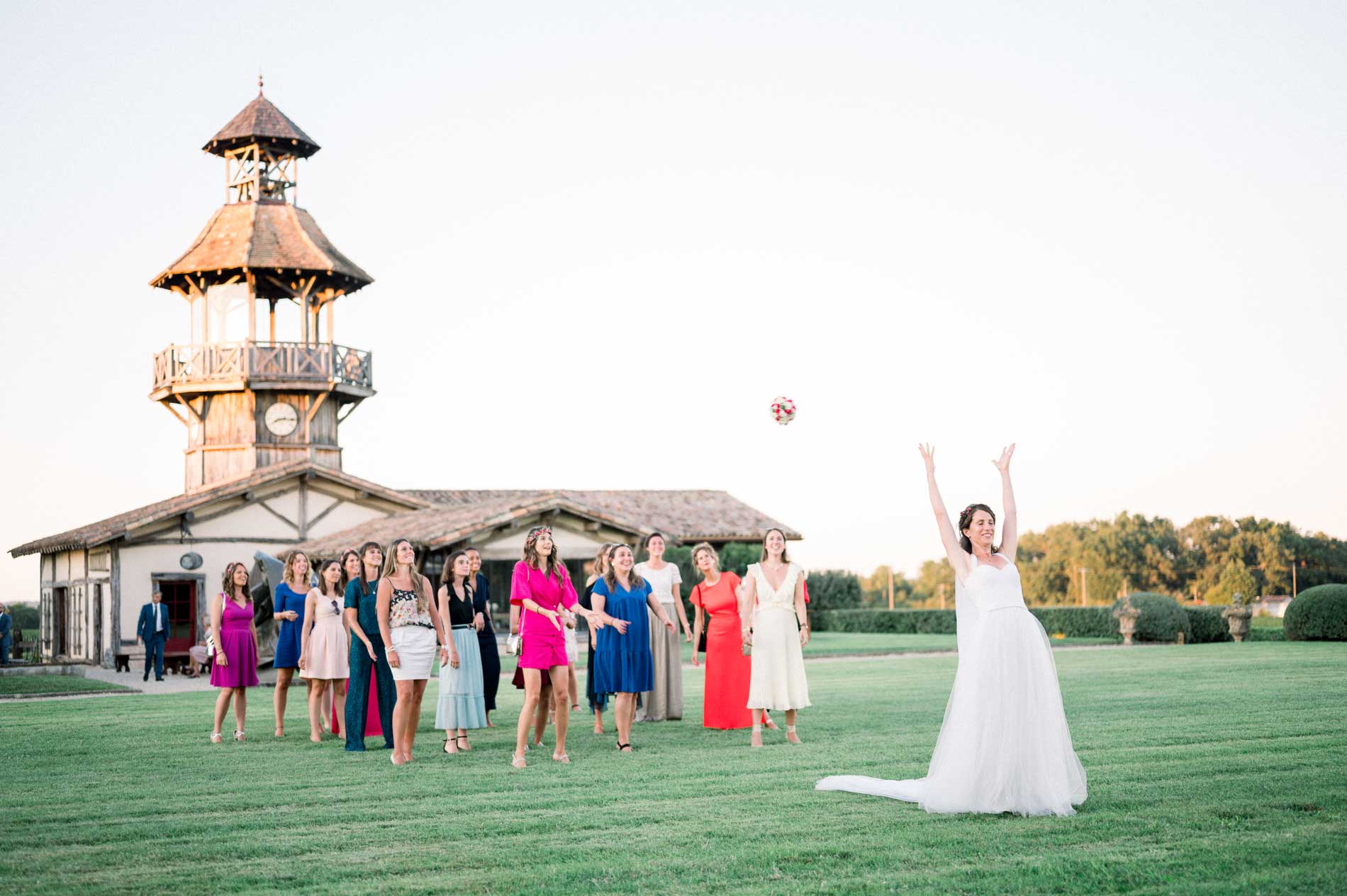 The bride tosses her bouquet on the lawn below the belvedere tower