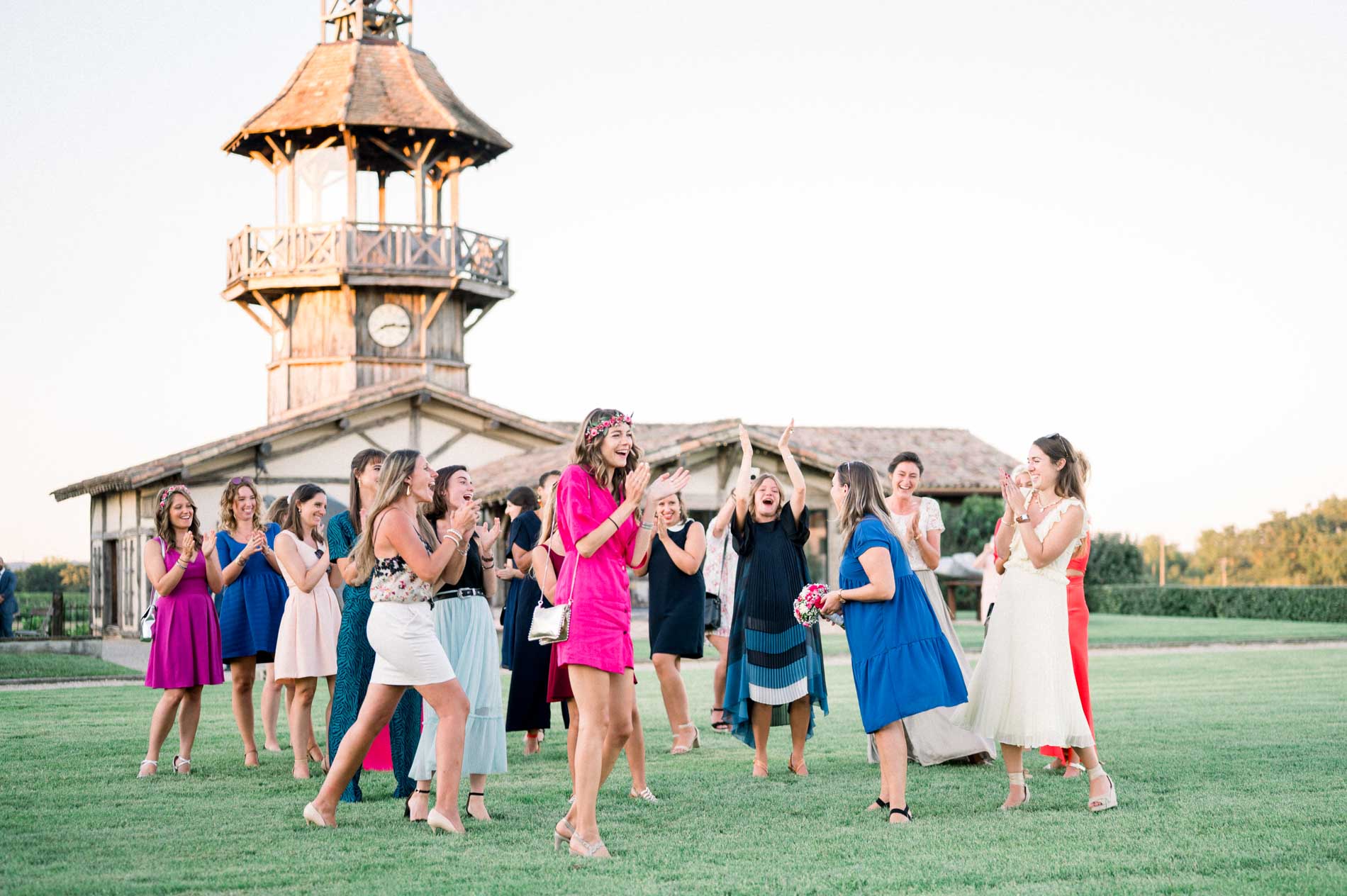 Guests scramble to catch the bridal bouquet in front of the château tower