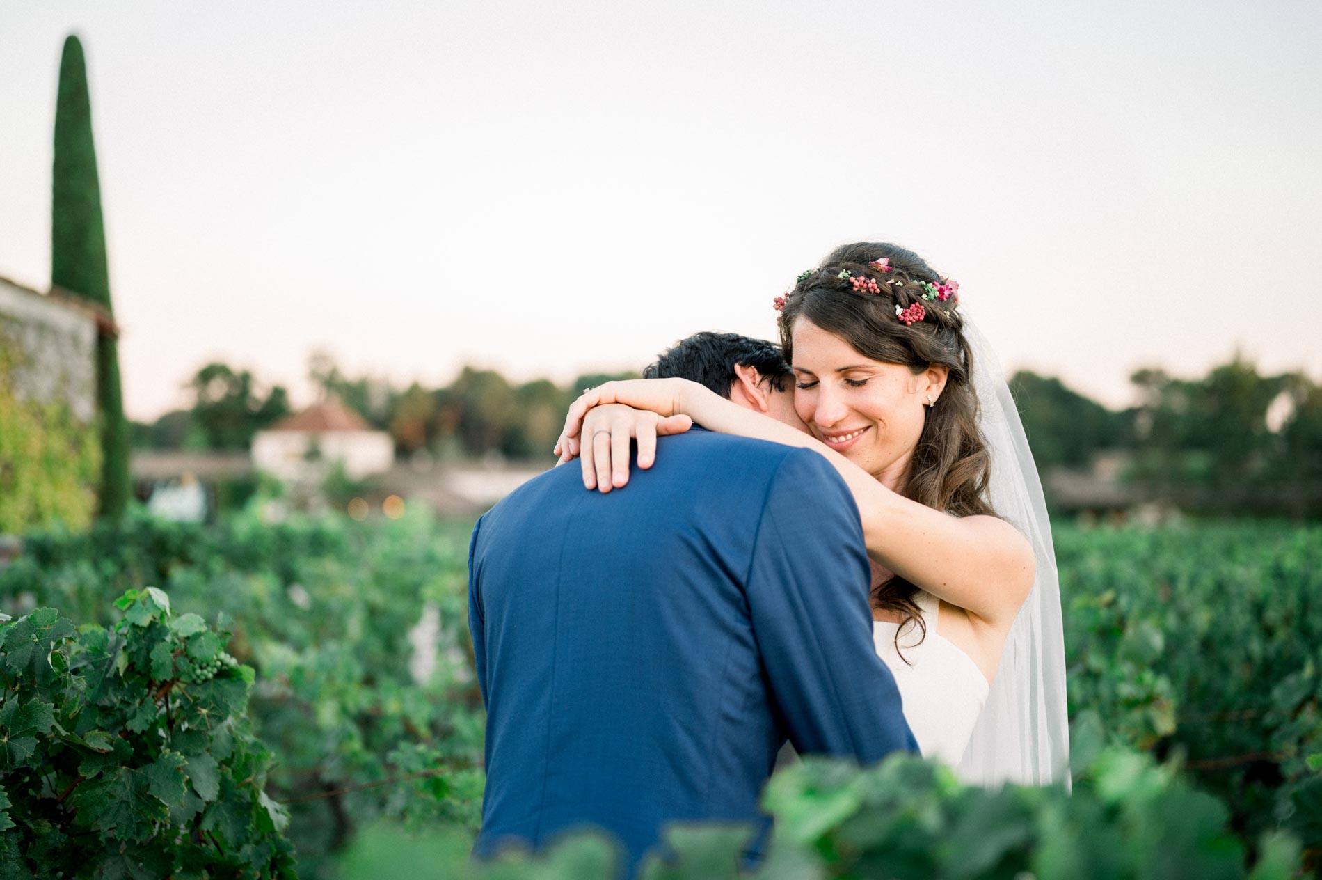 The couple embracing in the vineyard of Château Smith Haut Lafitte, cypress in the background