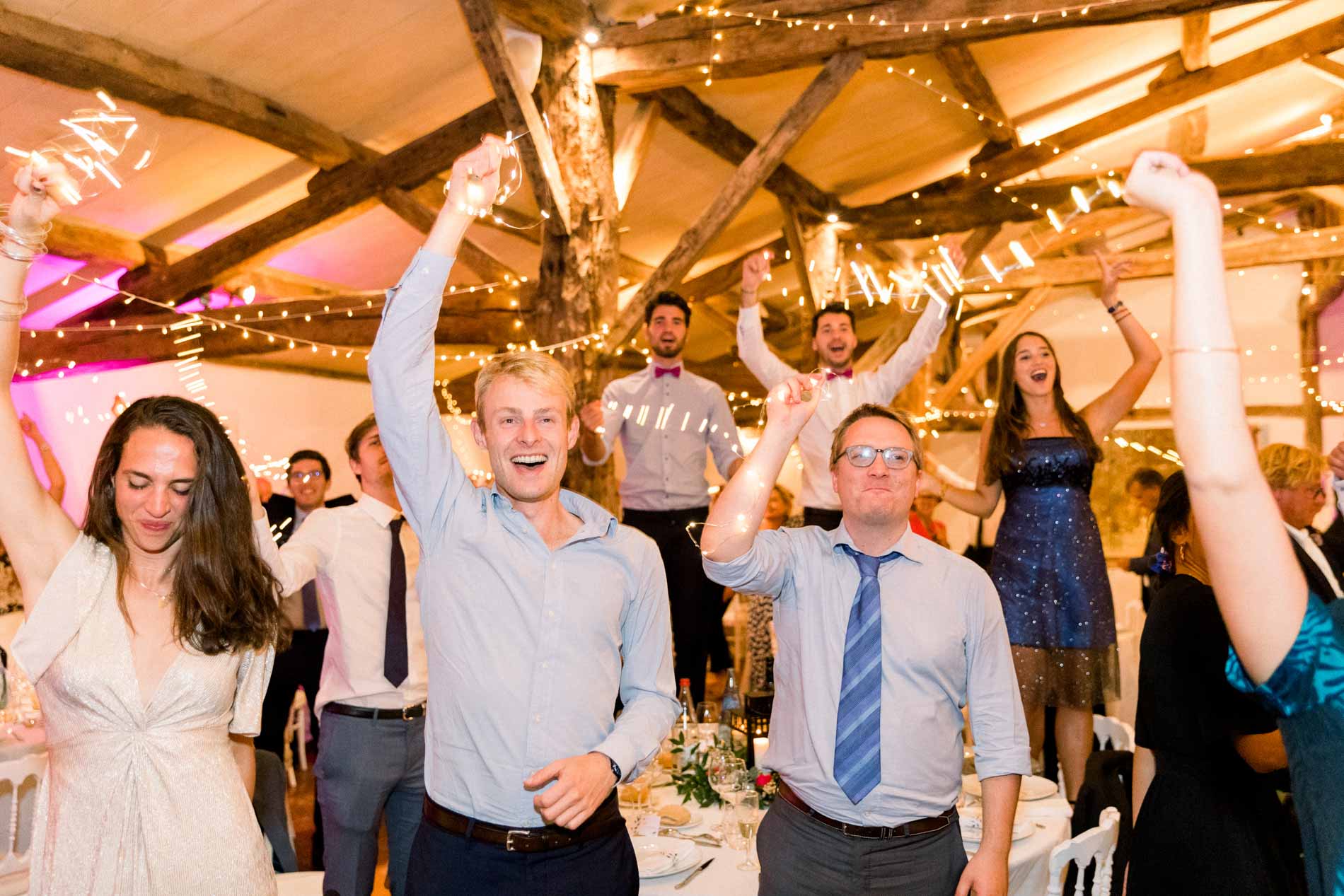 Guests throwing their arms up in the reception hall during the evening party