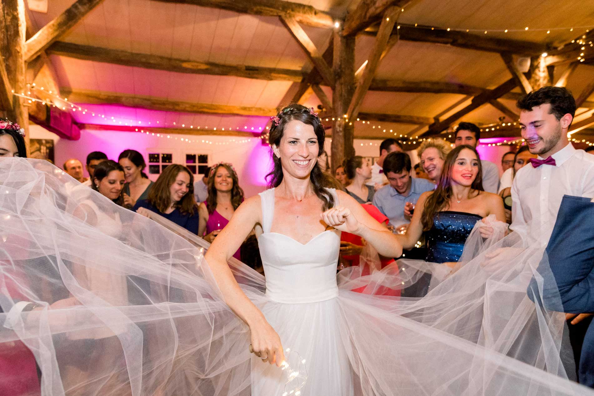 The bride dances, swirling her veil among the guests