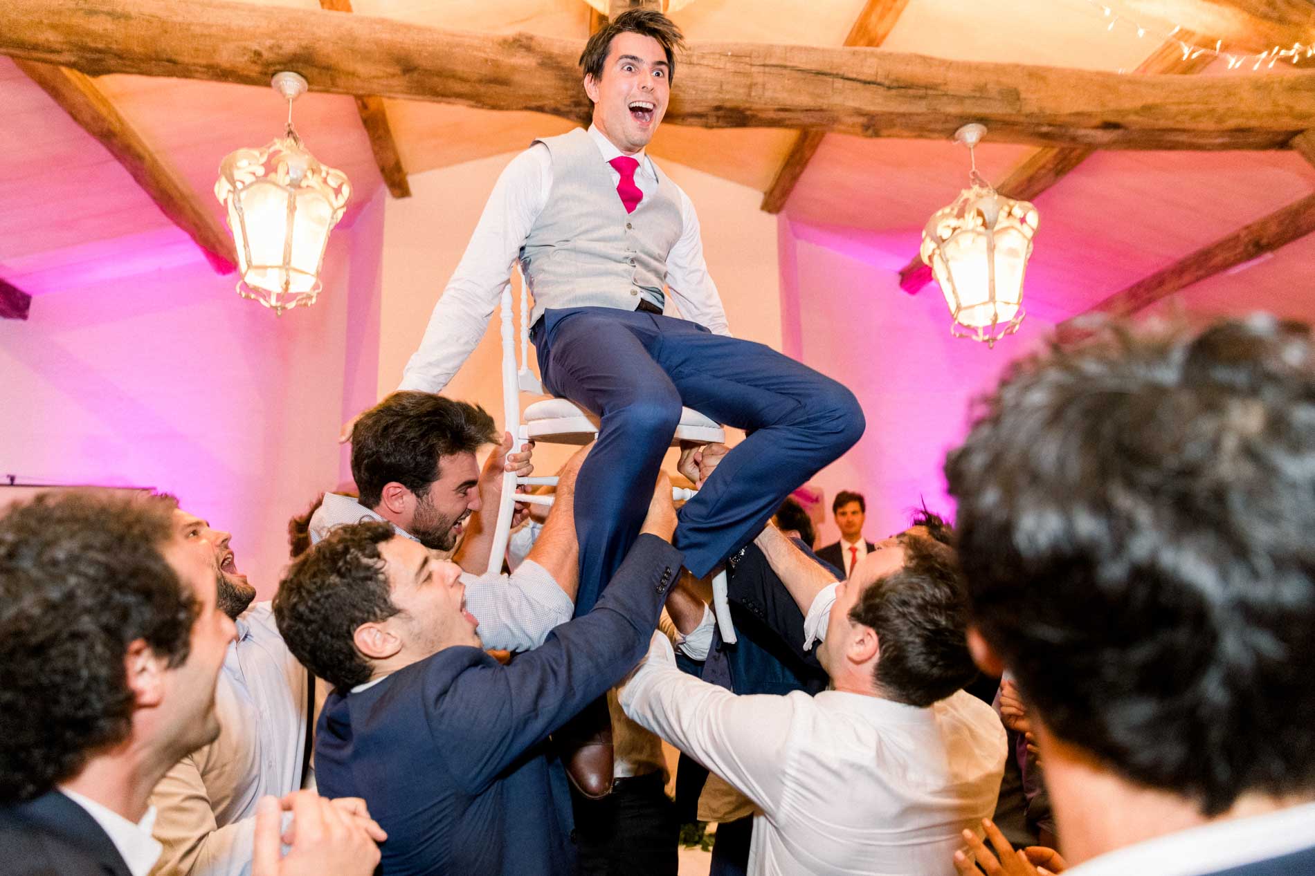 The groom lifted on a chair by his friends during the traditional dance