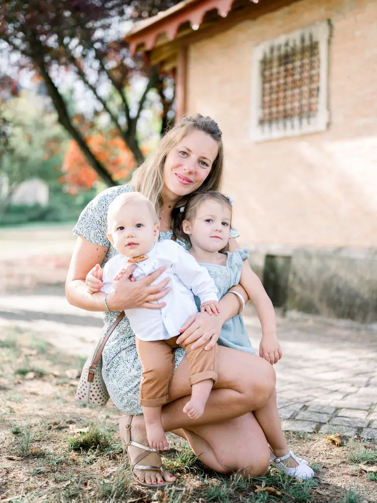 A guest crouching with two young children in her arms by the pavilion