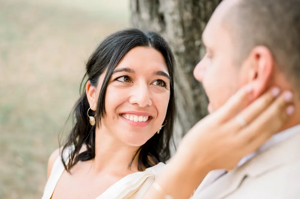 The bride laughing as she strokes the groom's cheek, close-up