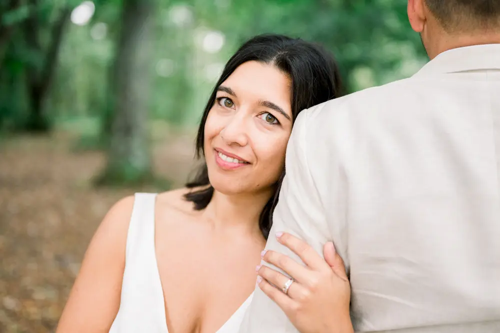 The bride resting her head on the groom's shoulder, smiling at the camera