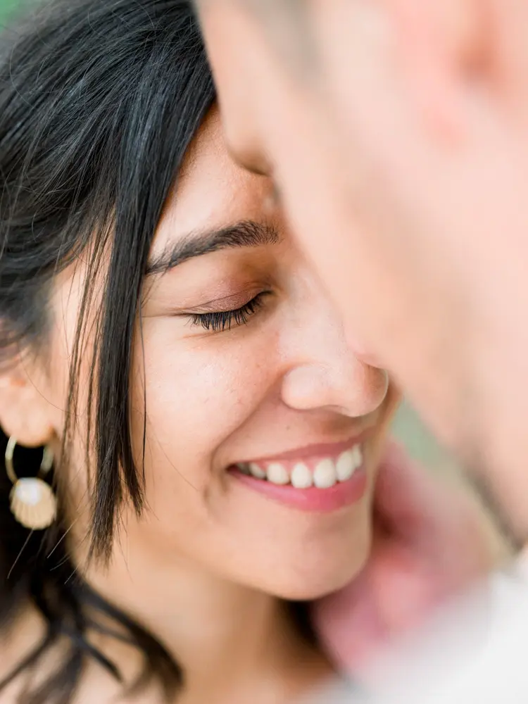 Close-up of the bride's smile, eyes closed, cheek against the groom