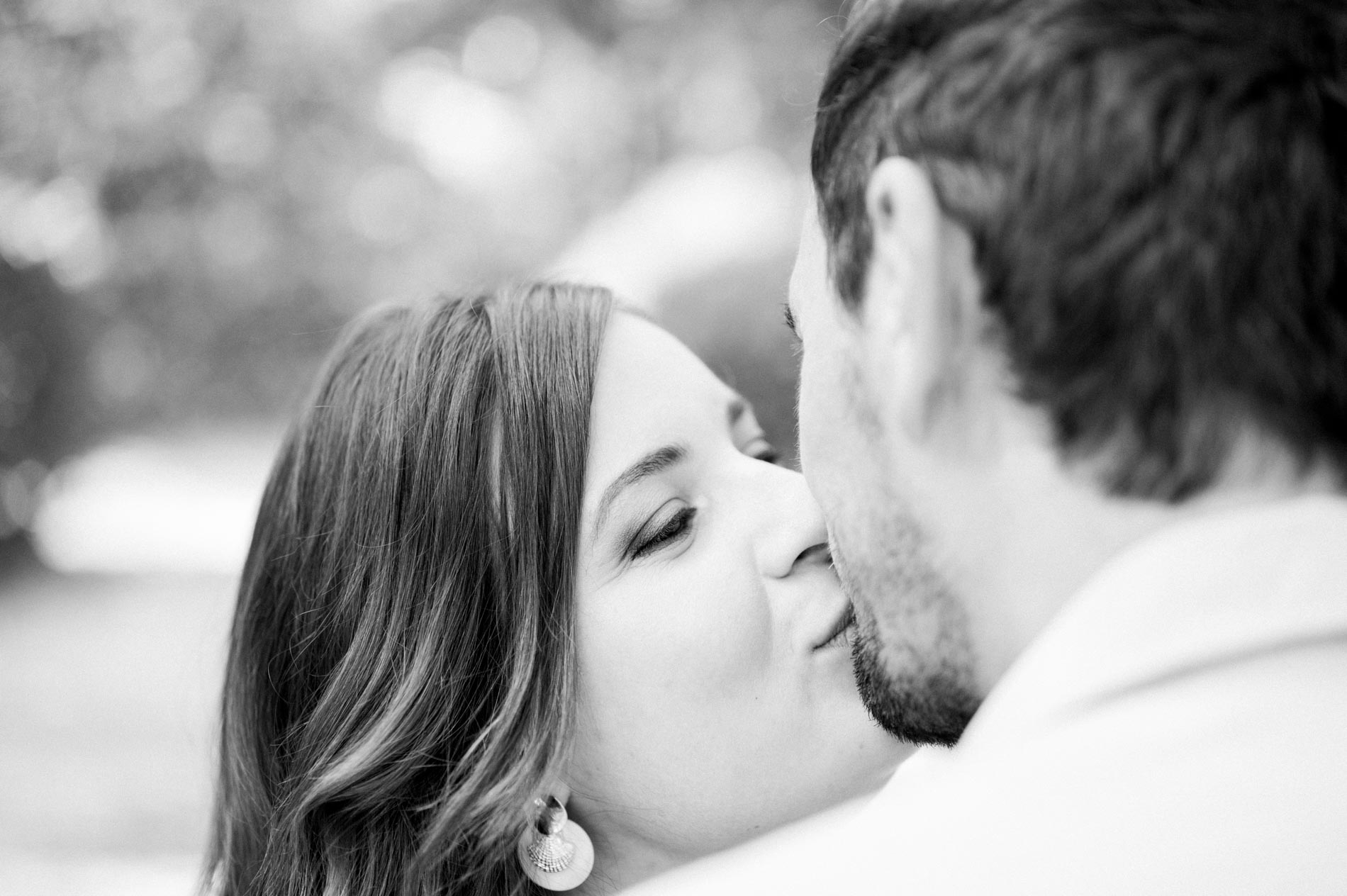 Close-up of the couple's tender kiss, in black and white