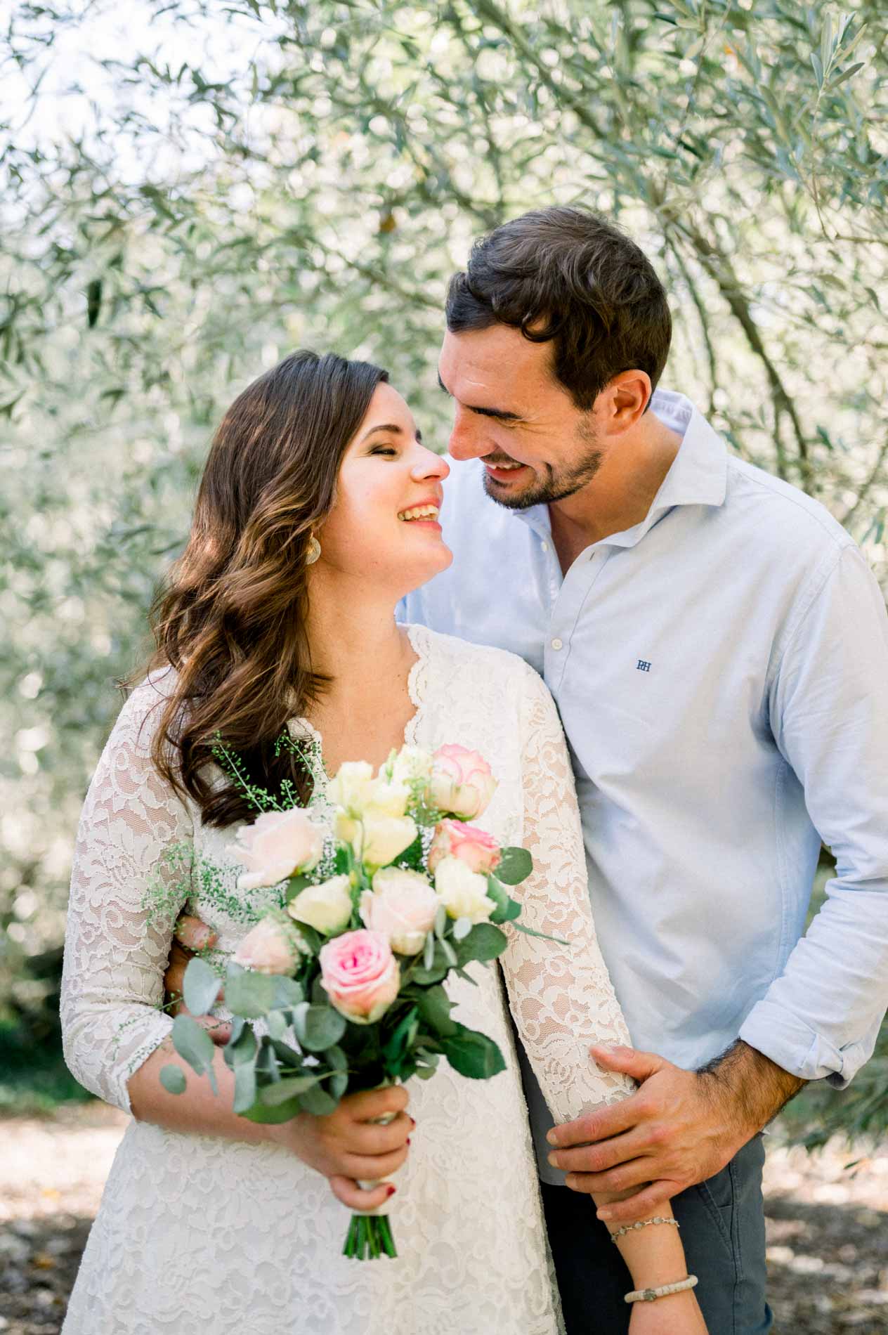 Smiling couple gazing at each other, rose bouquet between them
