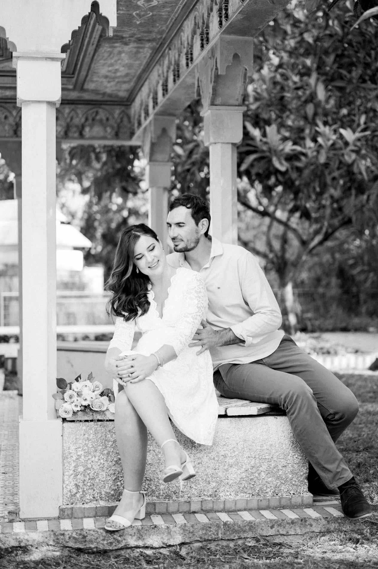 Couple sitting tenderly under the pavilion, in black and white
