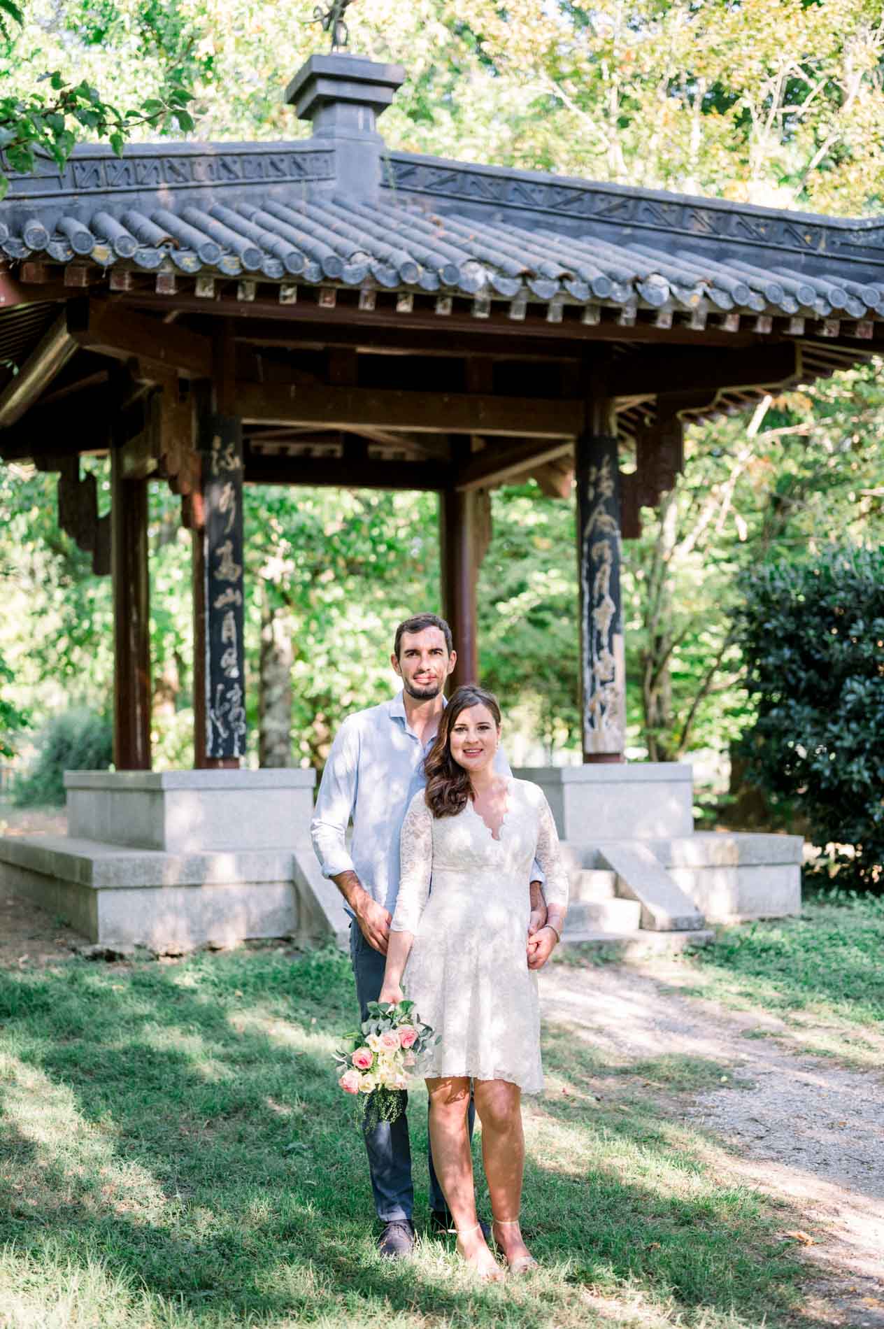 Parents-to-be standing before an Asian-style pavilion in the Barails garden