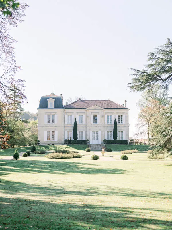 Château de Garde seen from its tree-filled park on an autumn day
