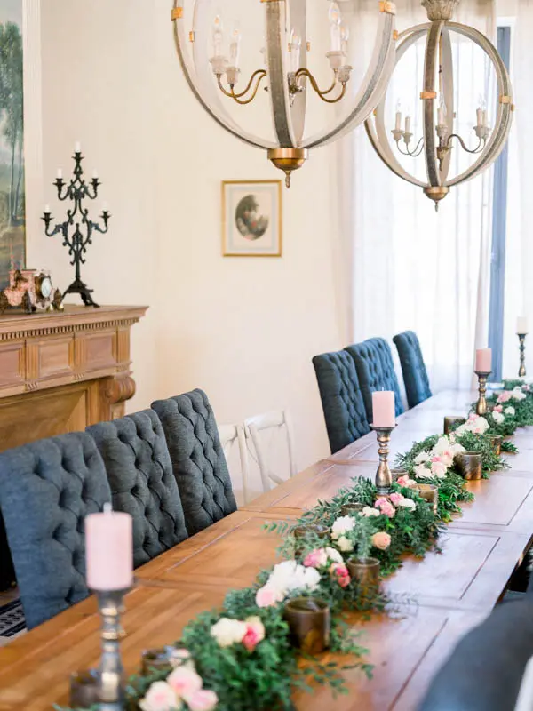 Long wedding table dressed with pink flowers and candles inside the château