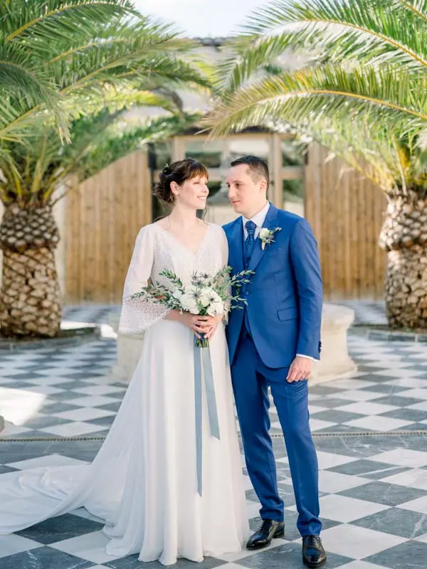 Bride and groom gazing at each other in the château's palm courtyard