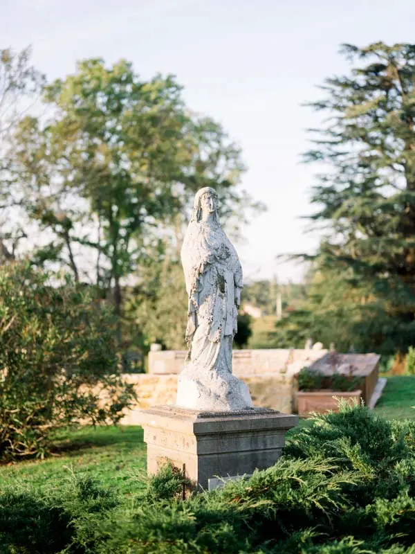 Stone statue among the trees of the Château de Garde gardens