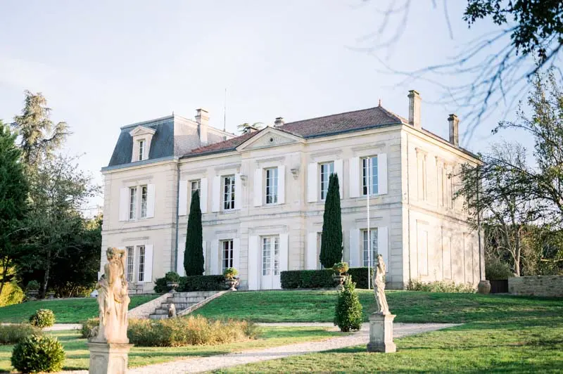Château de Garde façade with statues and cypress trees in the garden