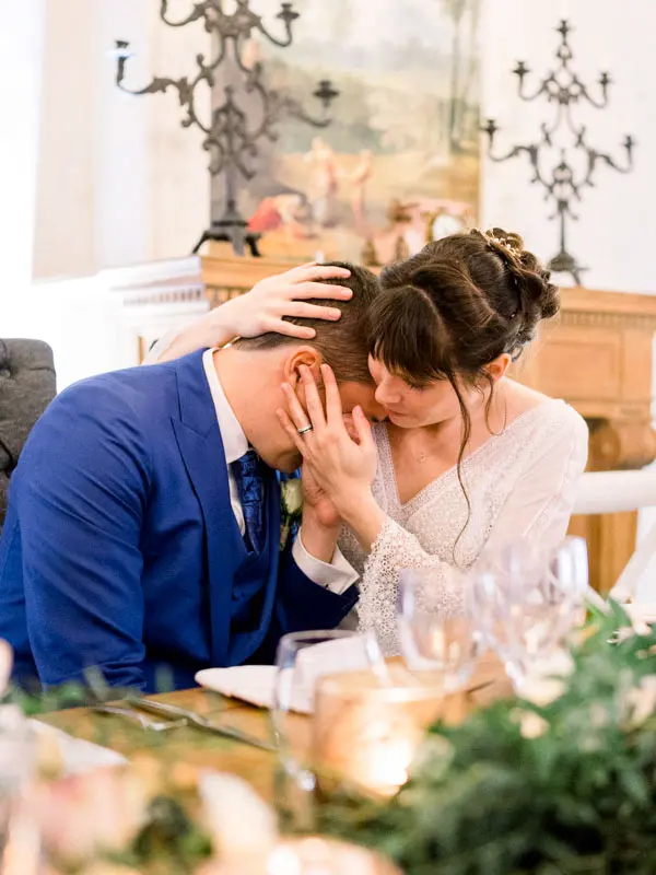 Emotional bride and groom forehead to forehead during a dinner speech