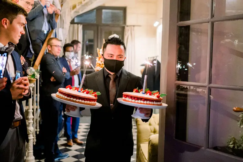 Waiters bringing in strawberry cakes topped with sparklers