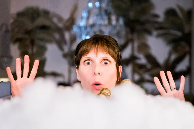 Surprised guest emerging from a cloud of white smoke as the cake arrives