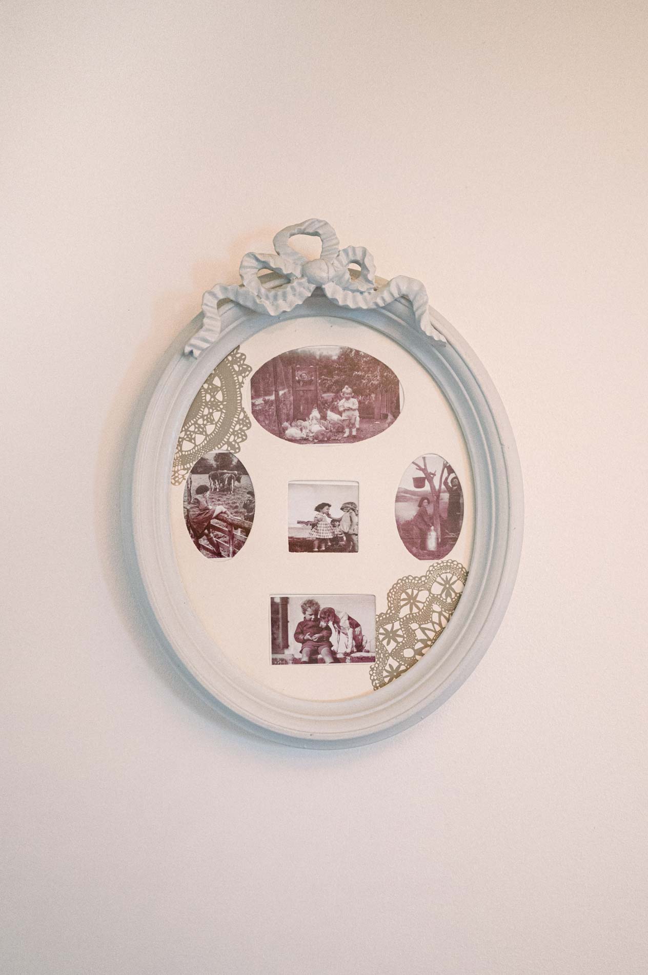 Ornate oval frame with a bow holding old family photographs