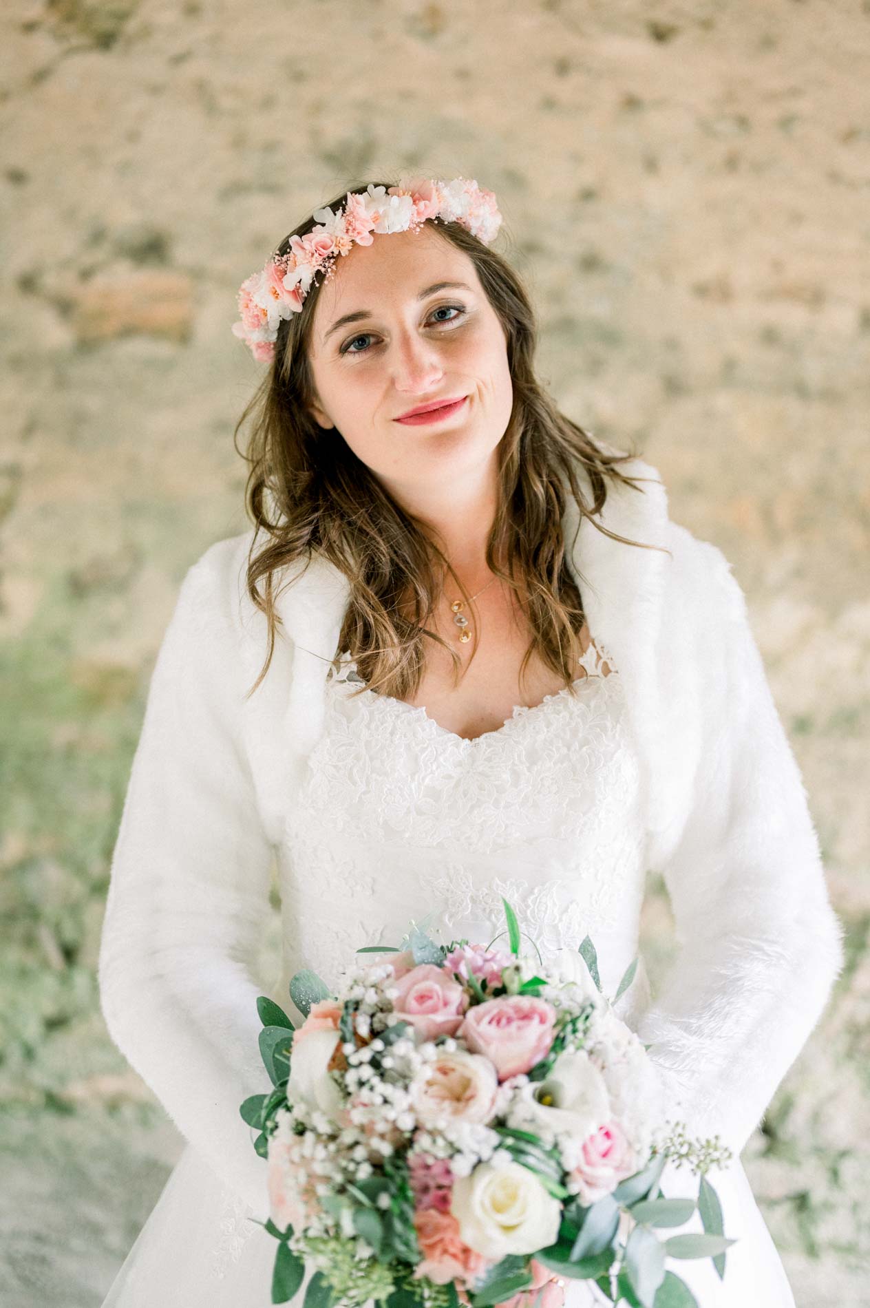 Portrait of the smiling bride with a flower crown and pink bouquet