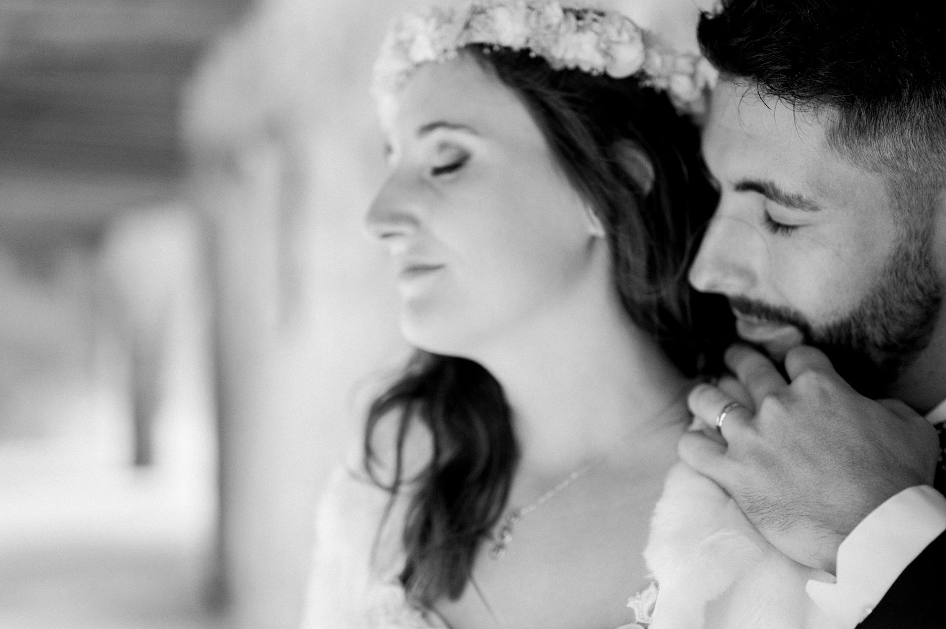 Groom resting his face against the bride, in black and white