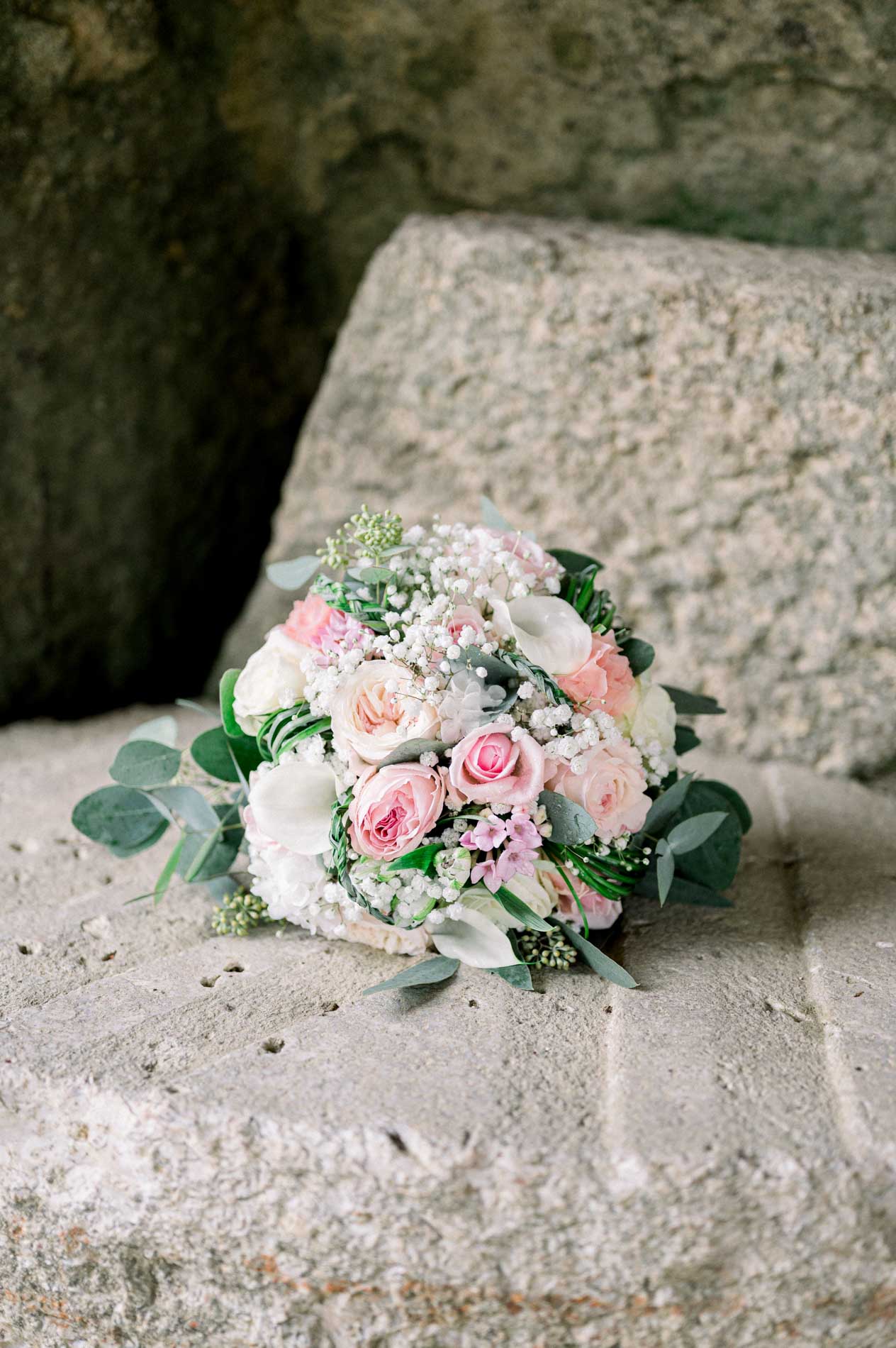 Bouquet of pink and white roses resting on a stone