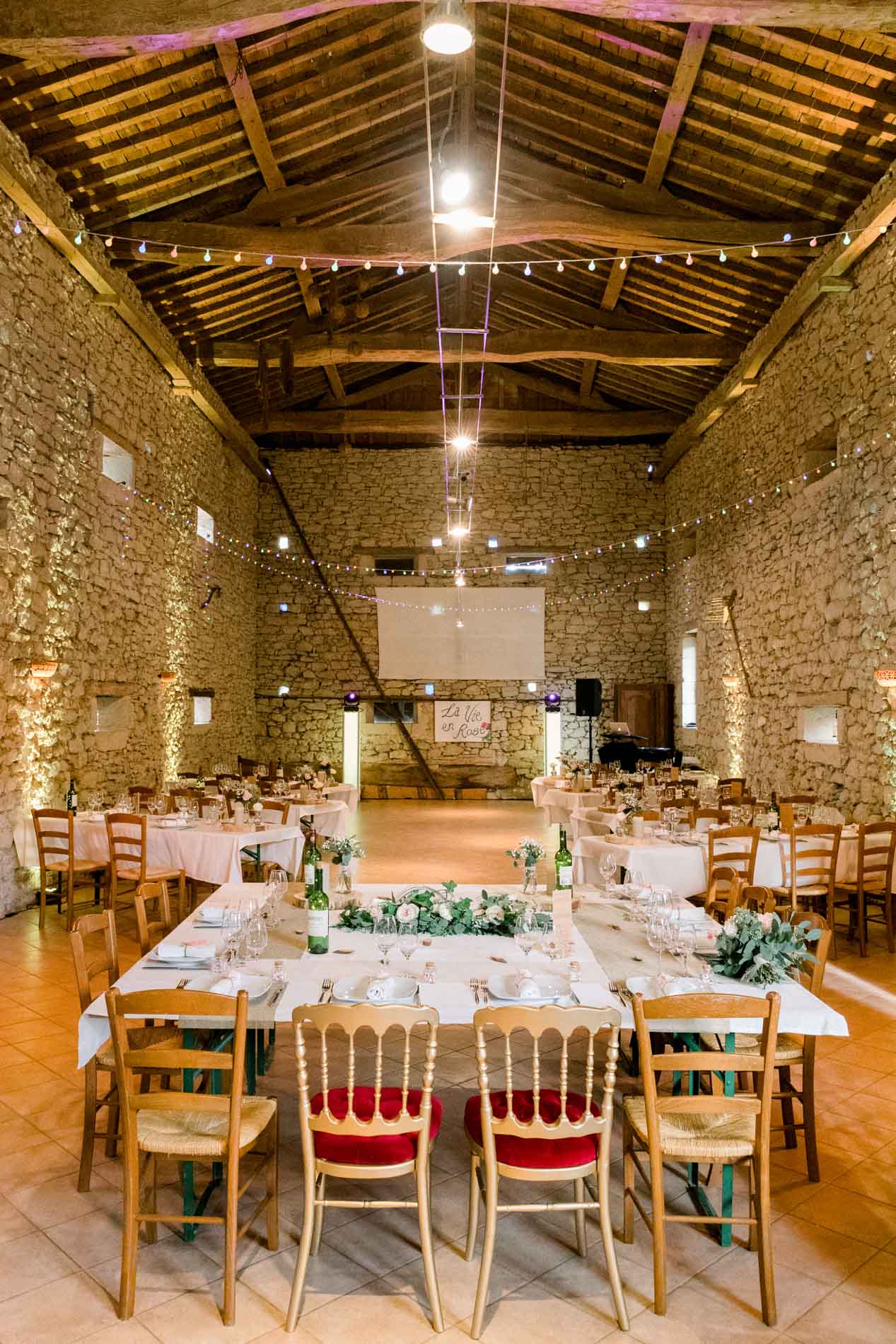 Reception hall under exposed beams in the barn at Ferme du Moulinat