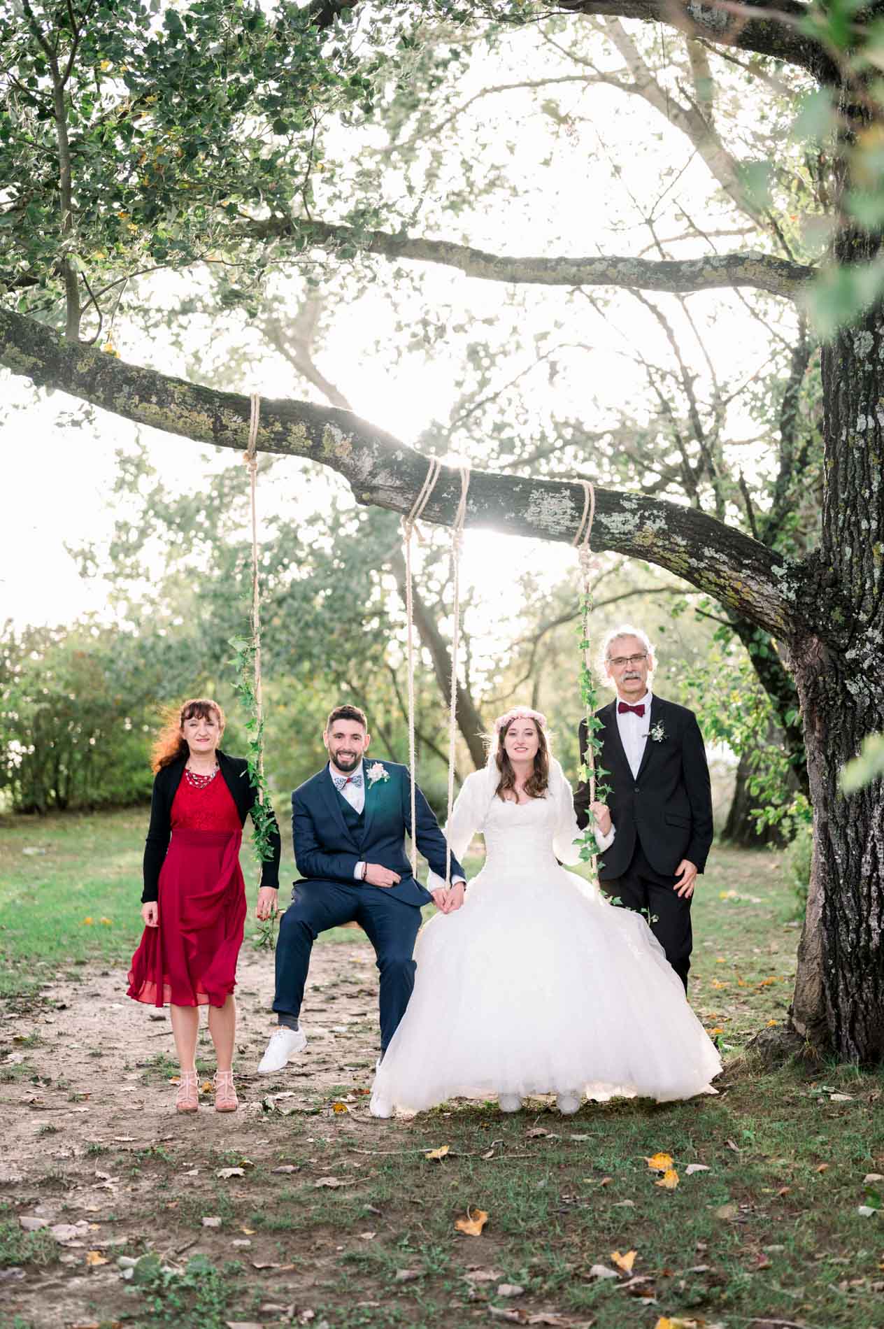 Bride and groom on a swing flanked by their witnesses under an oak