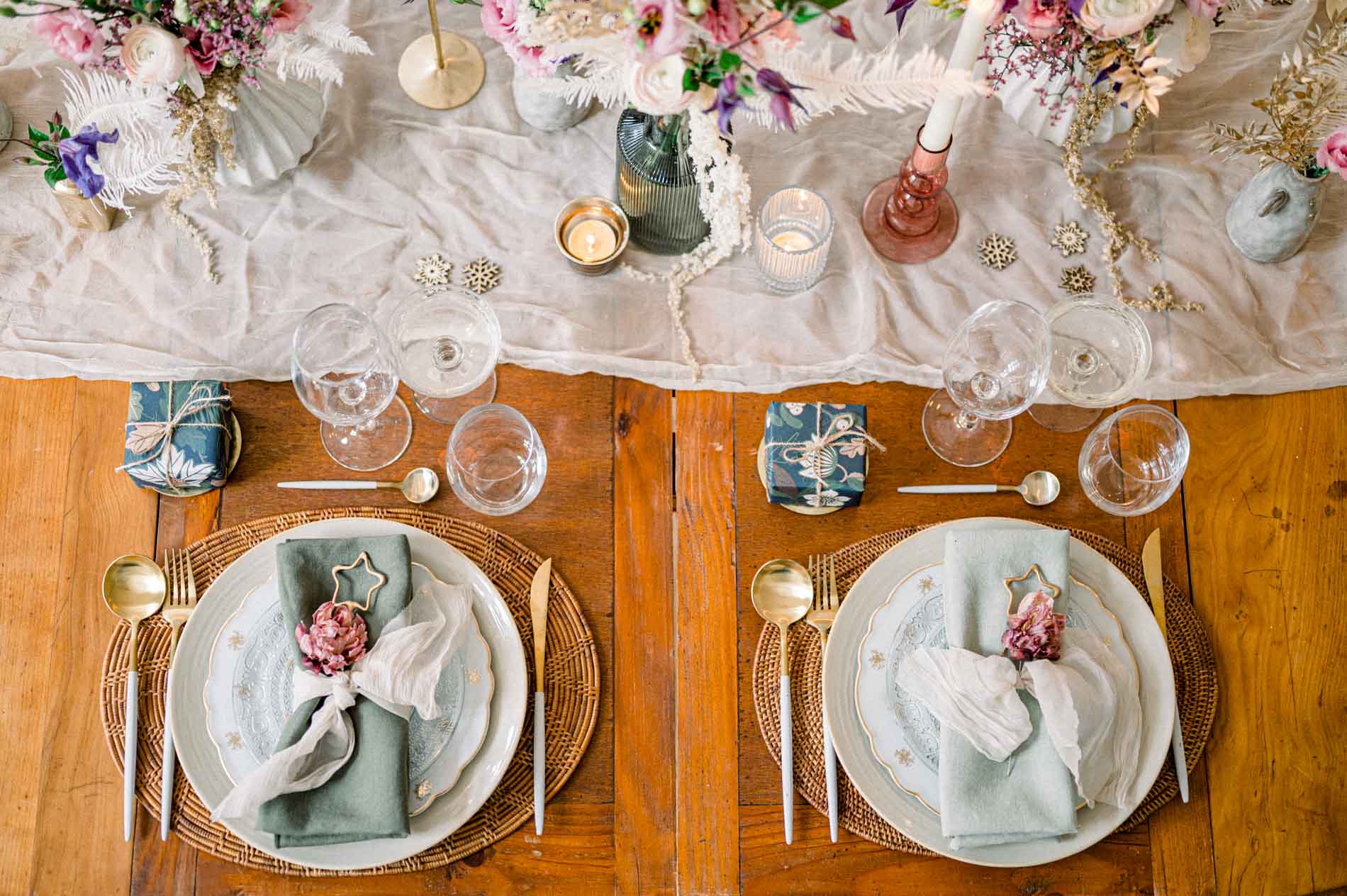 Overhead view of a fine art Christmas table with plates, sage napkins and dried flowers