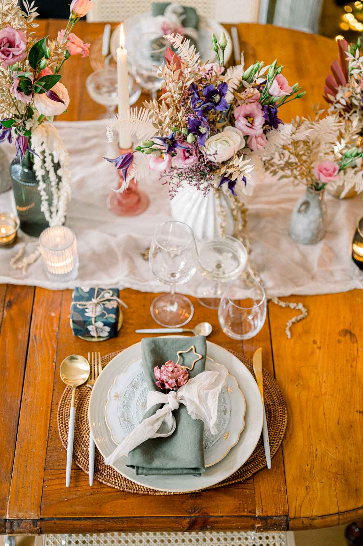 Christmas place setting on a wooden table with a purple dried flower bouquet