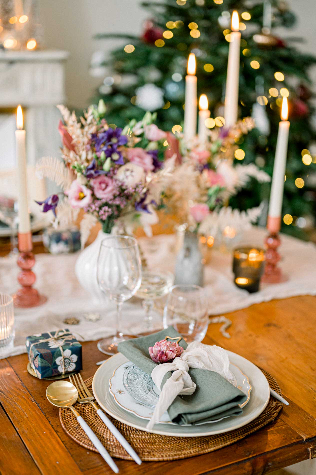 Plate and knotted napkin on the Christmas table, tree in the background