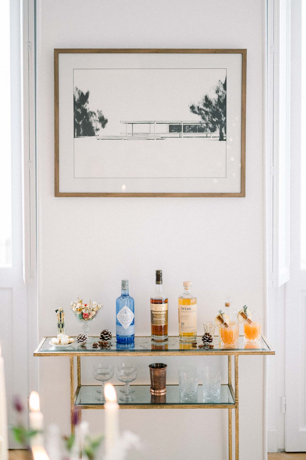 Gold drinks trolley with bottles and glasses beneath a framed print