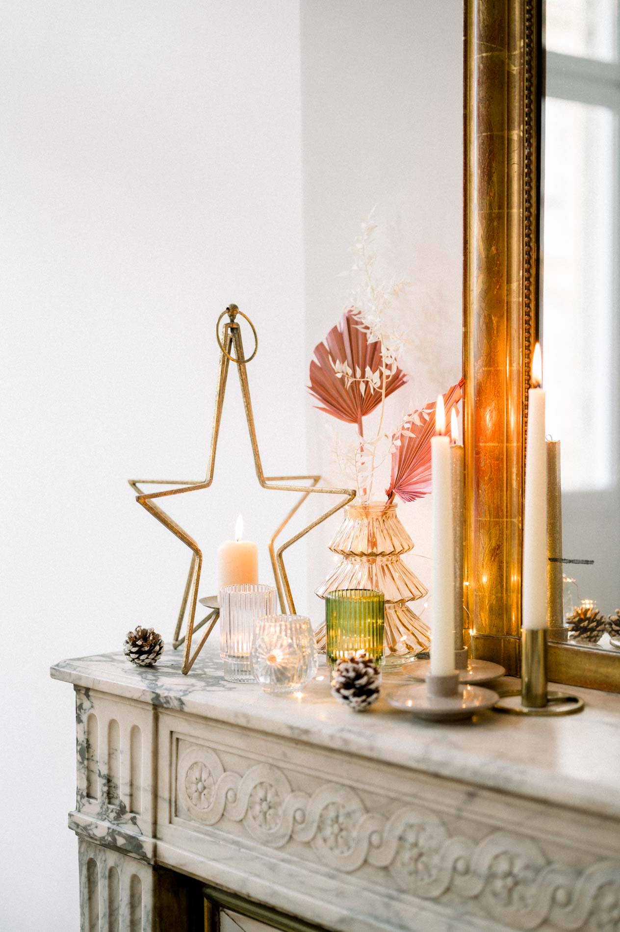 Gold star, candles and dried foliage on a carved fireplace