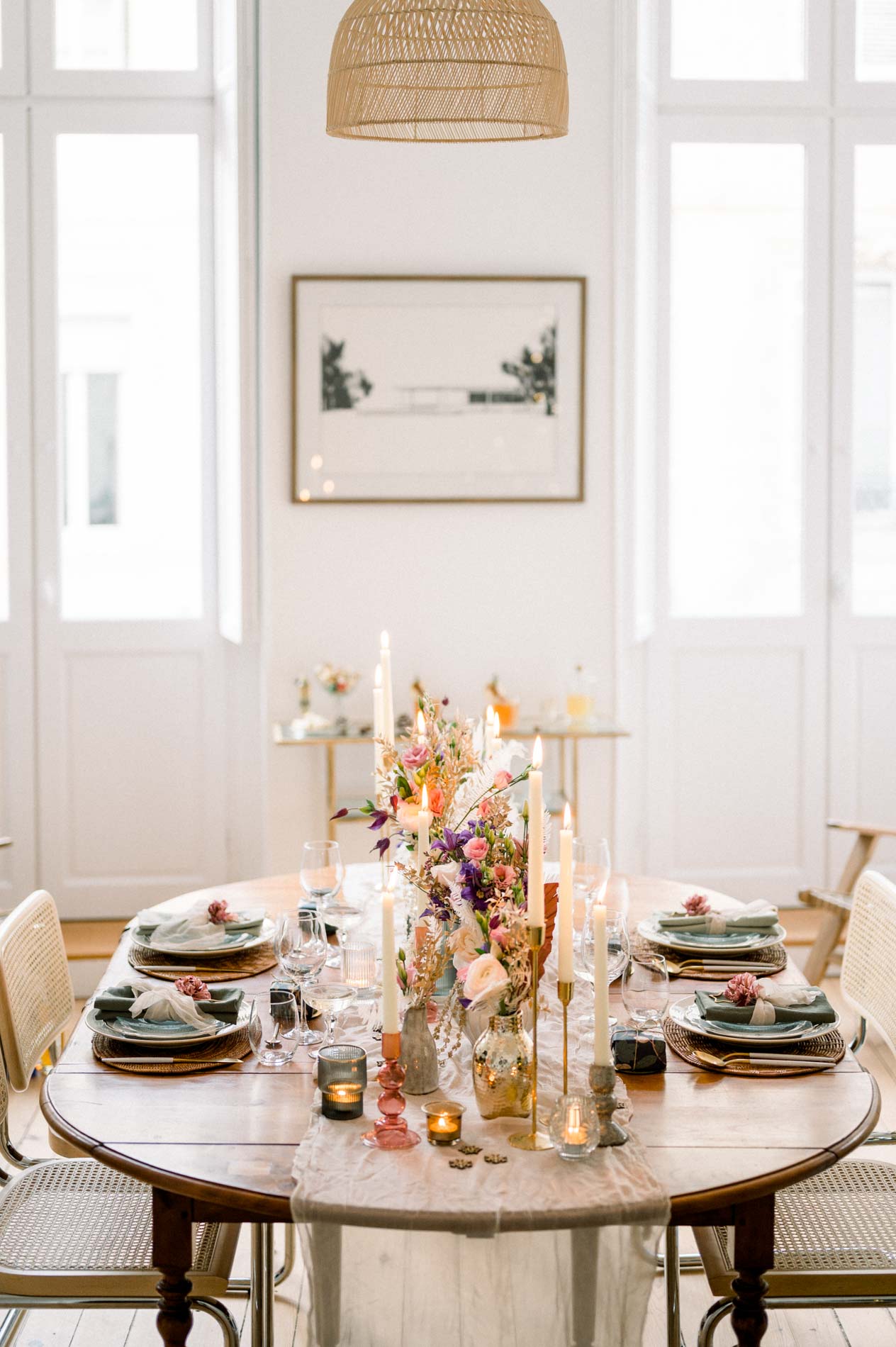 Christmas table set between two French windows under a rattan pendant