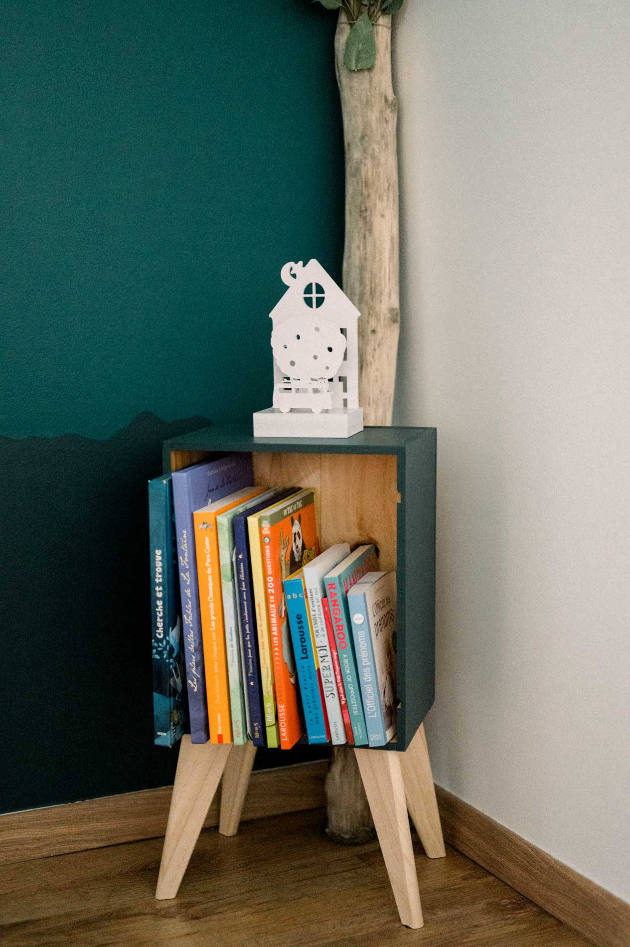 Livres colorés rangés dans un petit meuble de la chambre de bébé