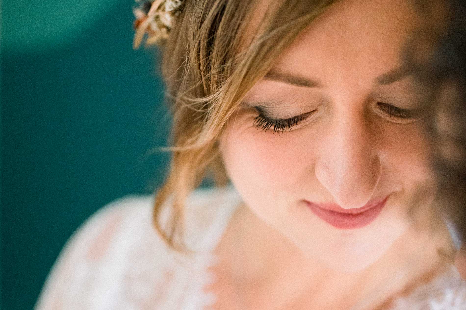Gros plan sur le visage souriant de la future maman, yeux baissés