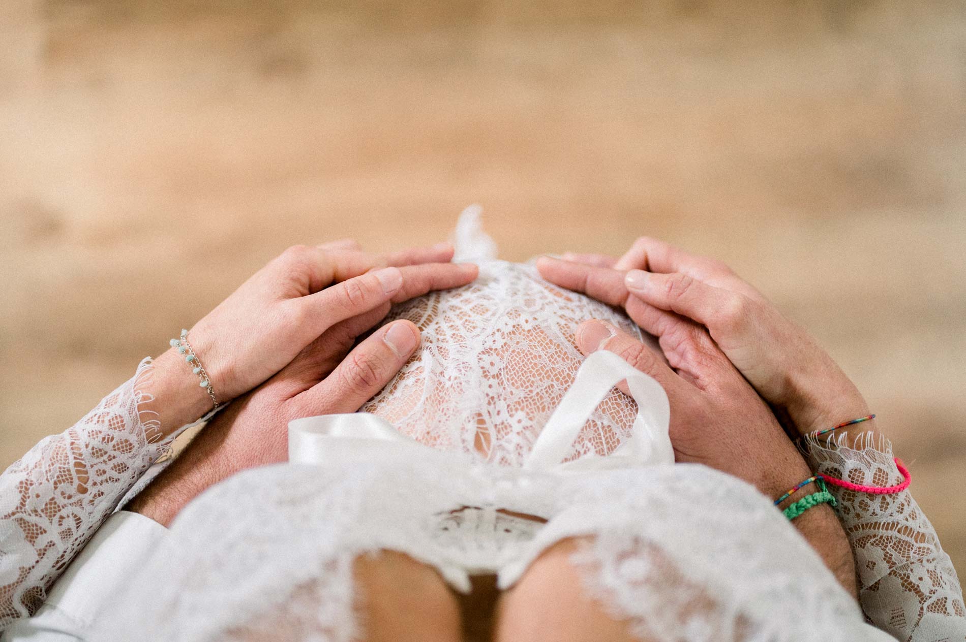 Mains des futurs parents posées sur le ventre en dentelle