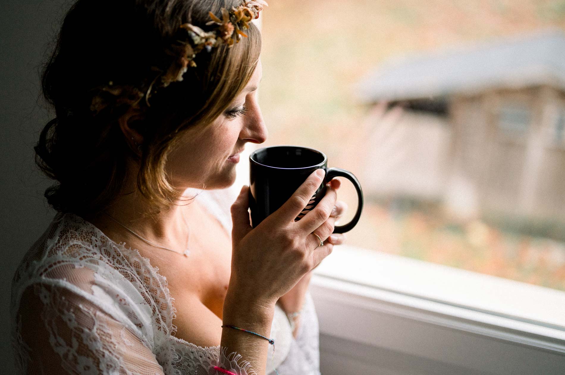 Future maman buvant dans une tasse noire face à la fenêtre