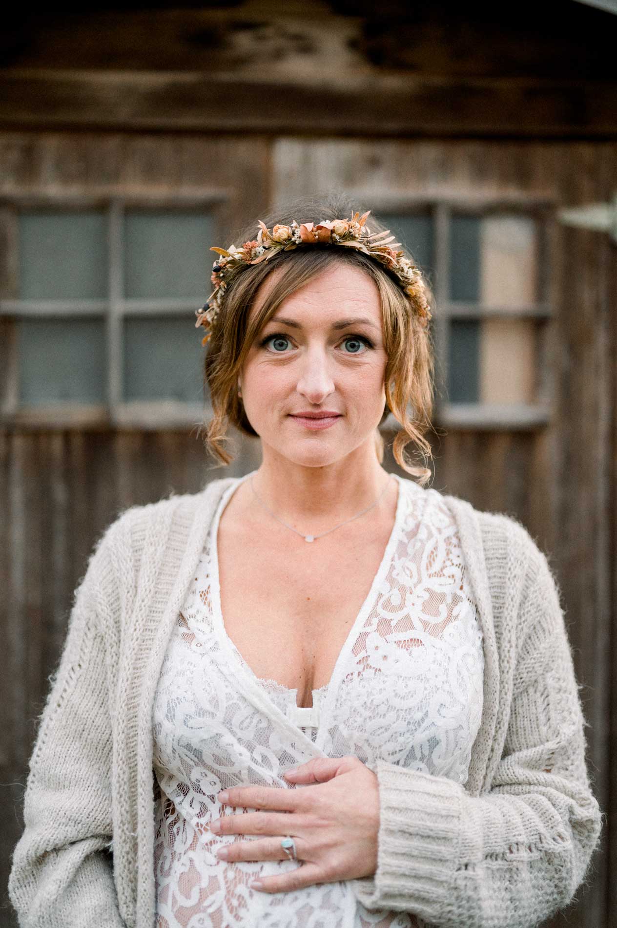 Portrait de la future maman en couronne dorée devant la porte en bois