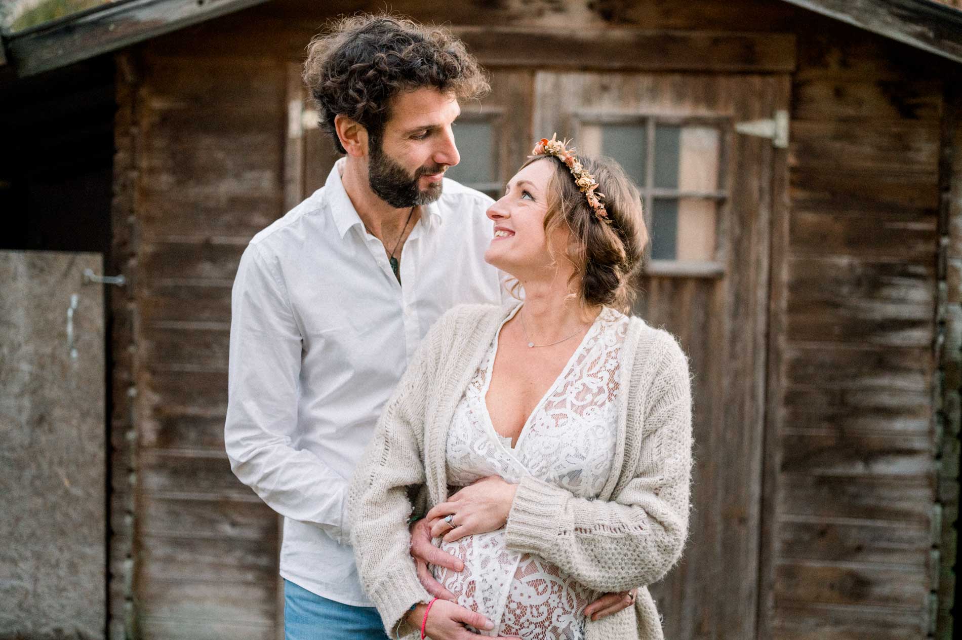 Futurs parents se regardant tendrement devant la cabane du jardin