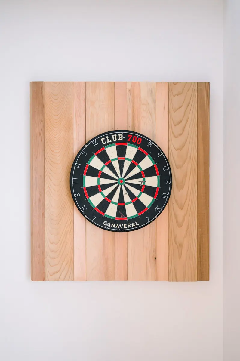 Dartboard on a light wooden board hanging on the wall