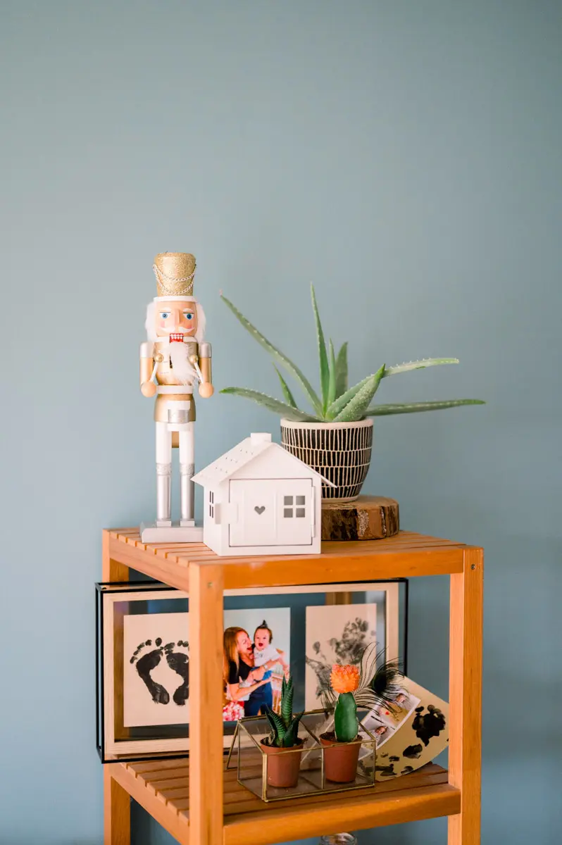 Orange shelf with a nutcracker, a plant and framed family photos