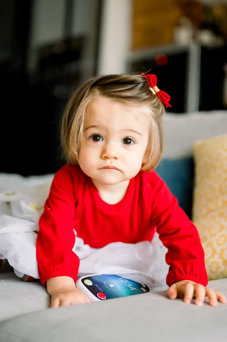 Little girl with a serious look crawling on the sofa