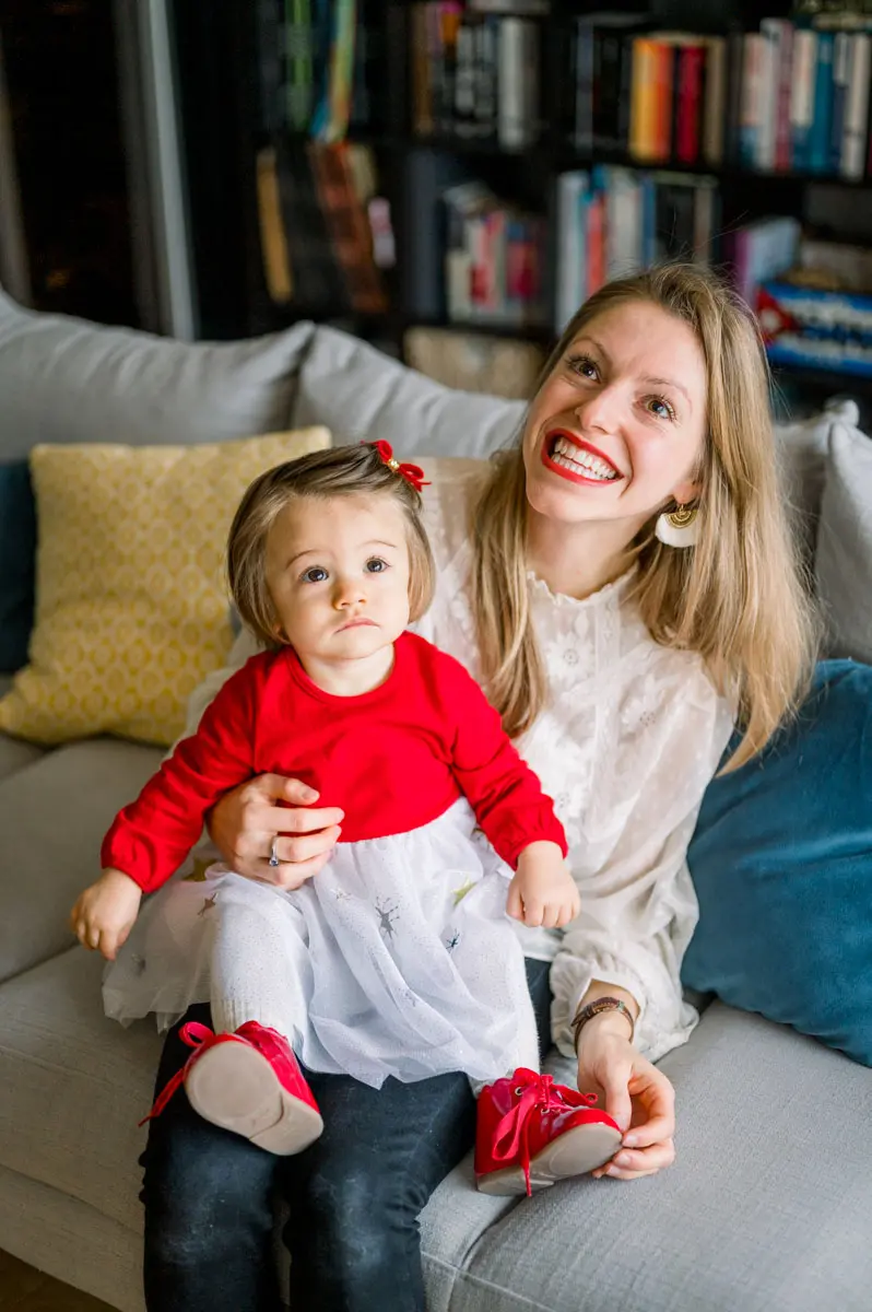 Mother and daughter sitting on the sofa in front of a bookcase