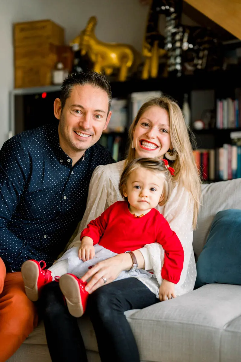 Family portrait on the sofa, the little girl on her parents' laps