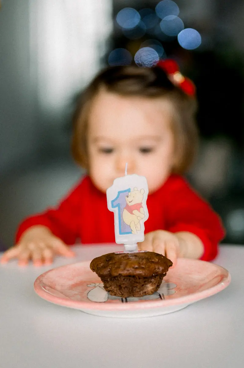 Little girl in front of her chocolate cake with a number one candle