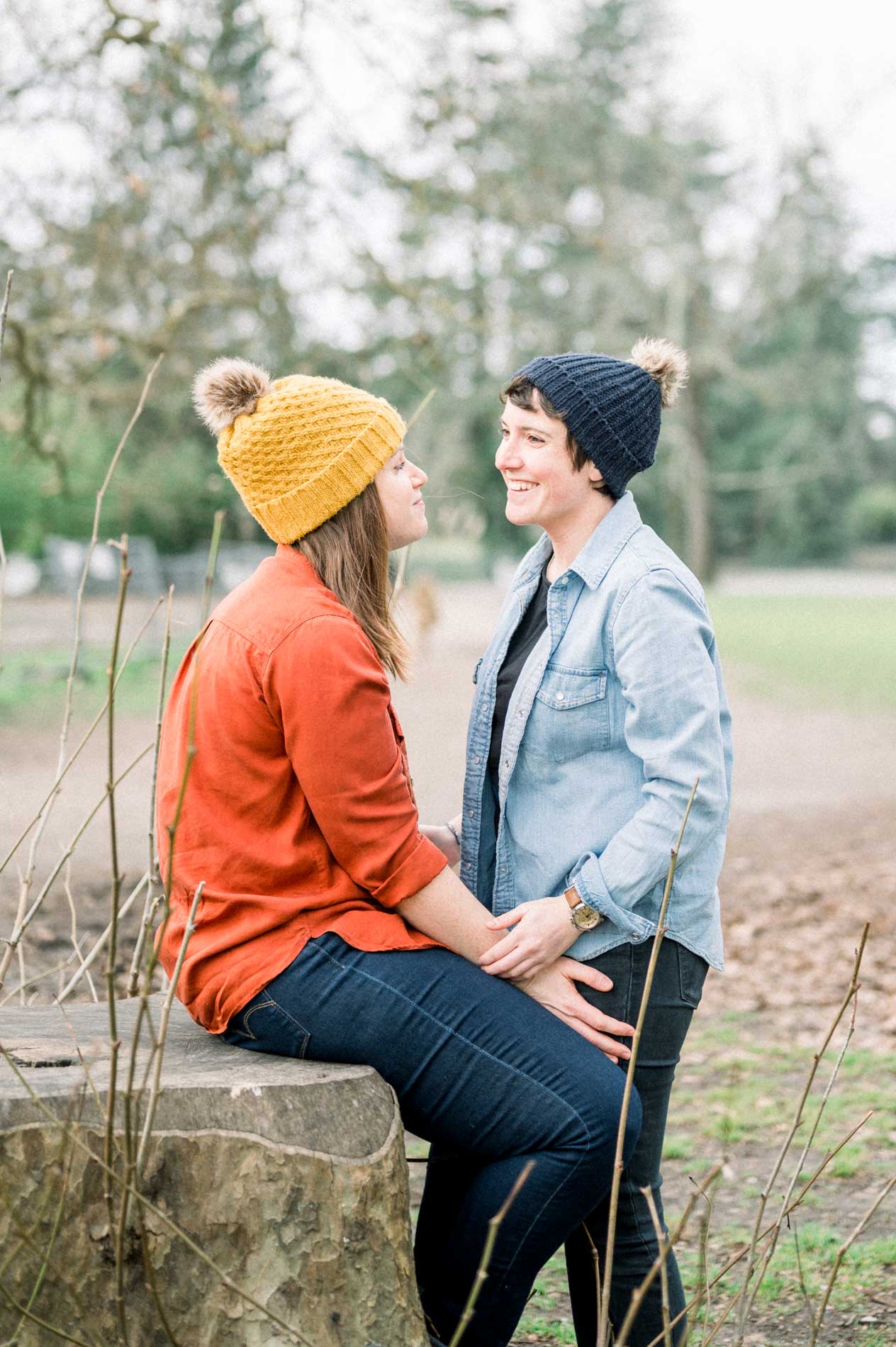 Two women smiling at each other during a park photo session