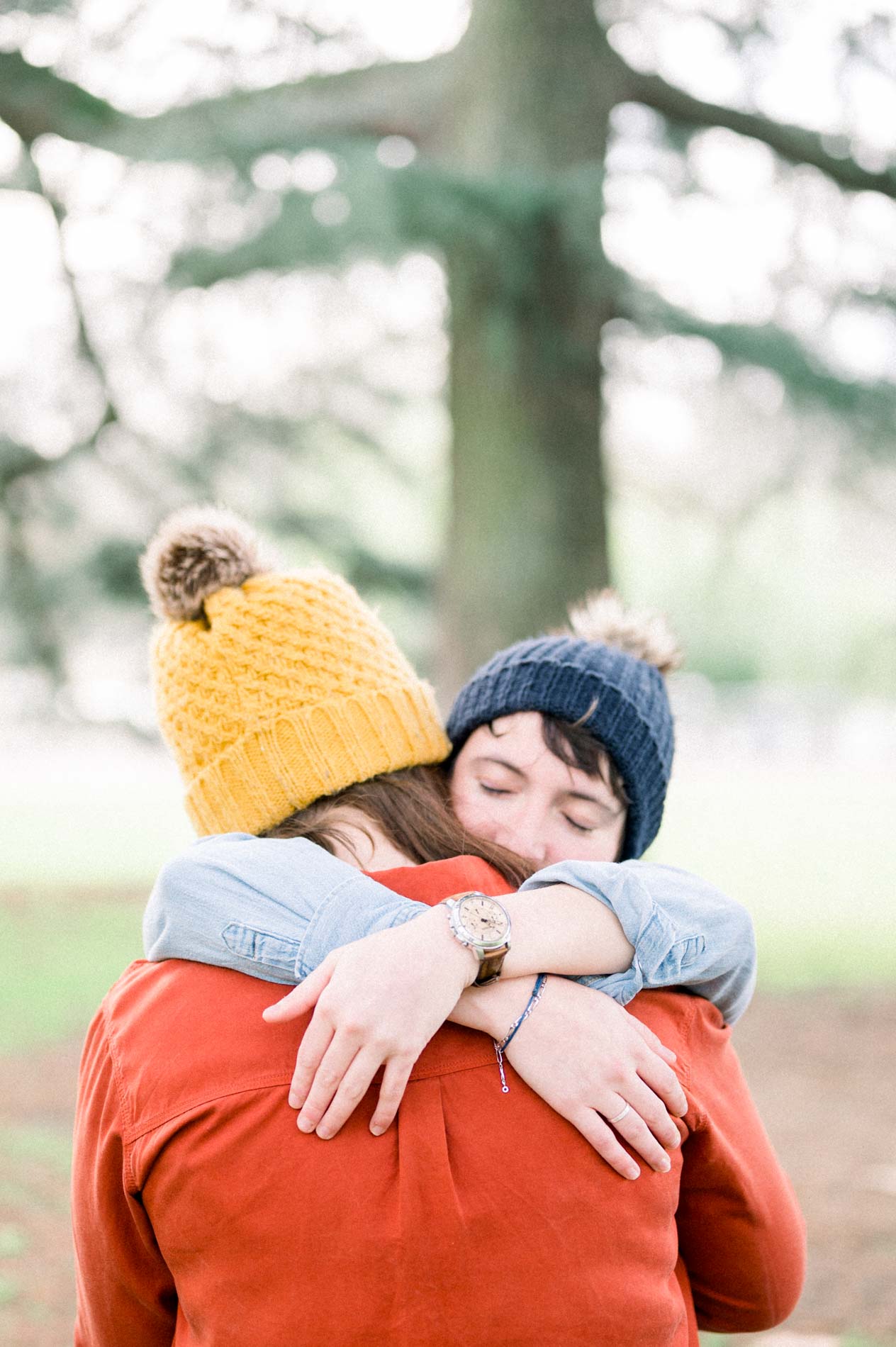 Tender hug between two women in beanies in the Parc Bordelais