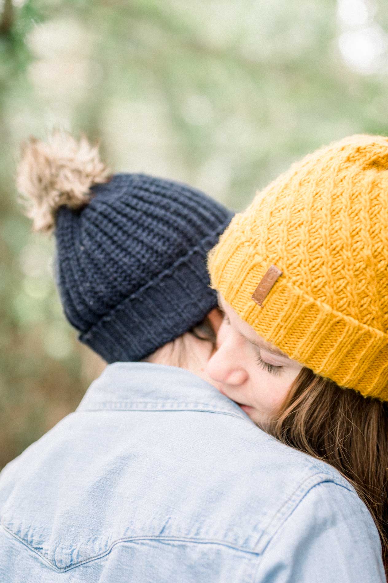 She rests her cheek on her partner's denim-clad shoulder