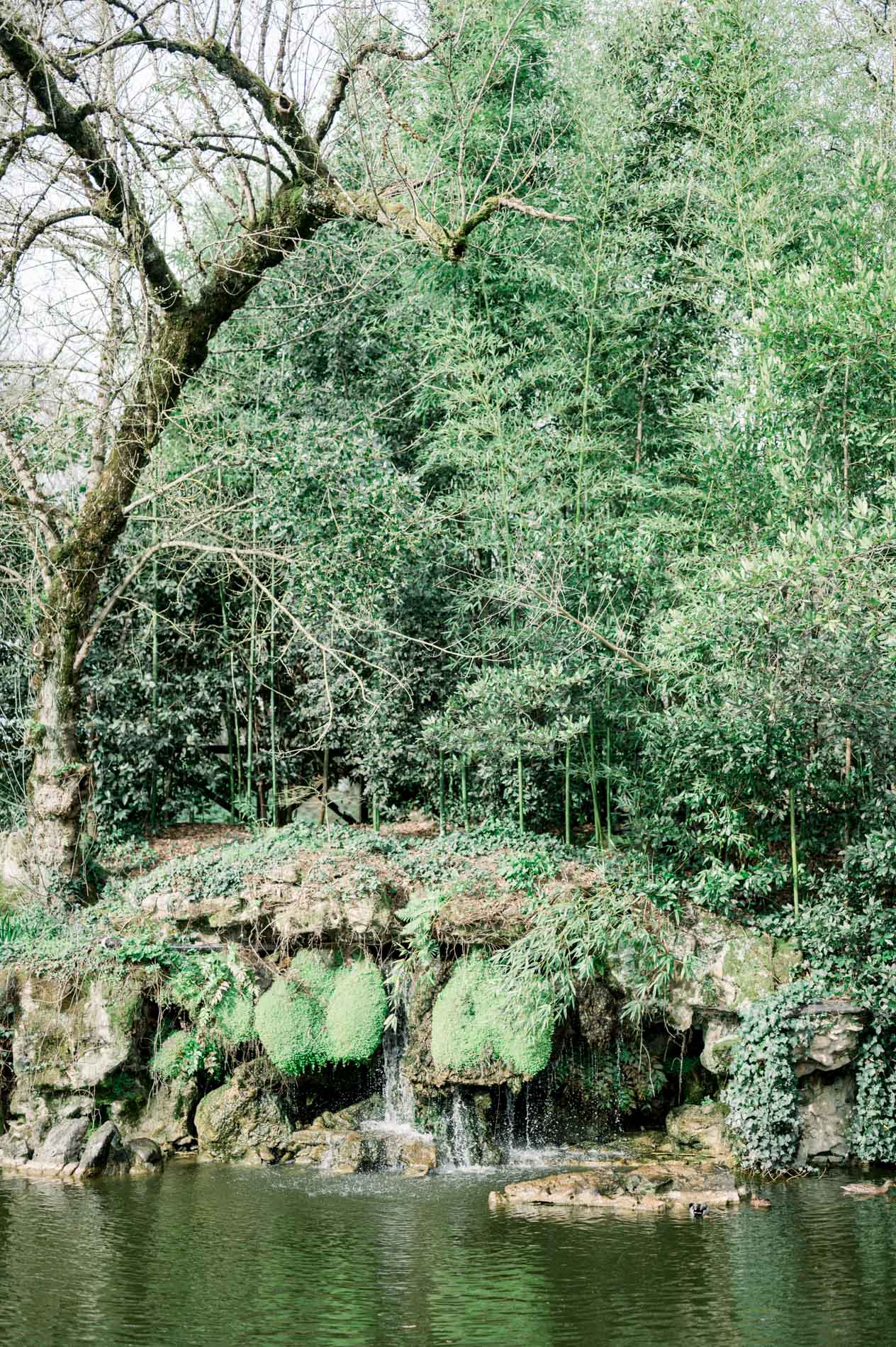 Waterfall and mossy rocks beside the Parc Bordelais pond
